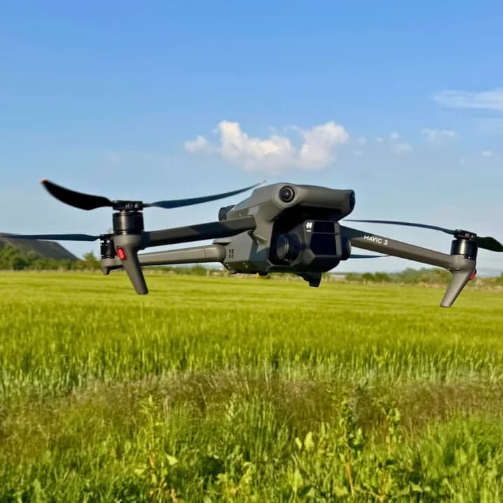 Bear Media Mavic 3 drone hovering above a green field
