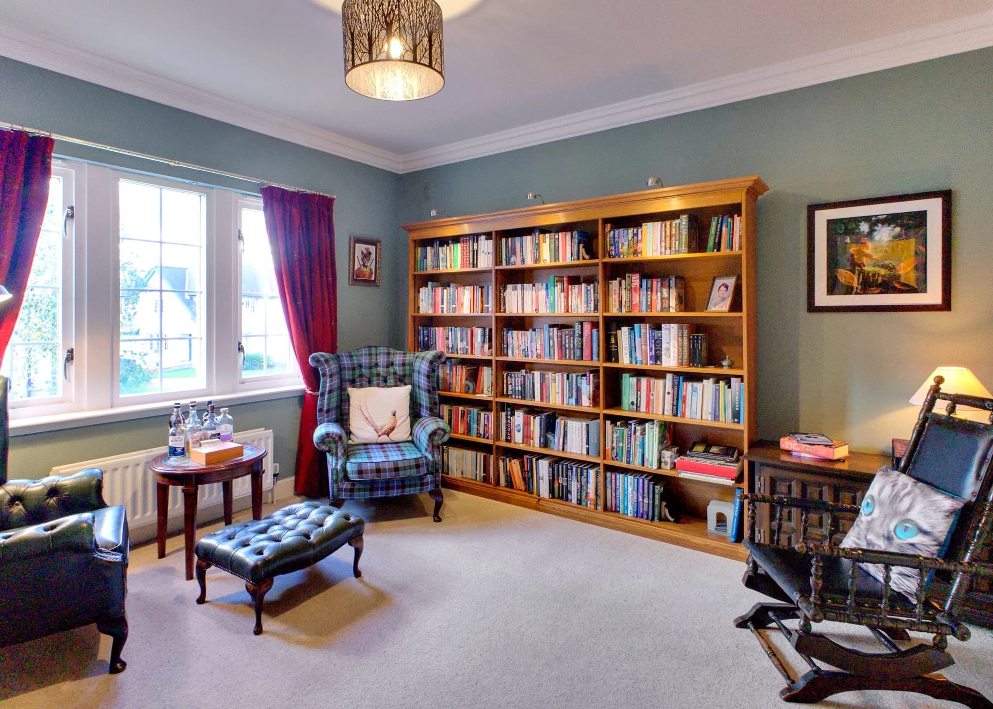 Library at 10 Burnet Crescent, with full bookshelves, reading chairs and a large window