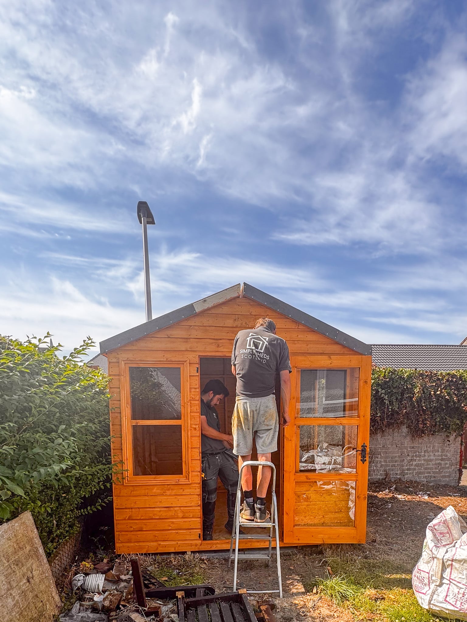 Simply Sheds Scotland installers finishing a timber garden building