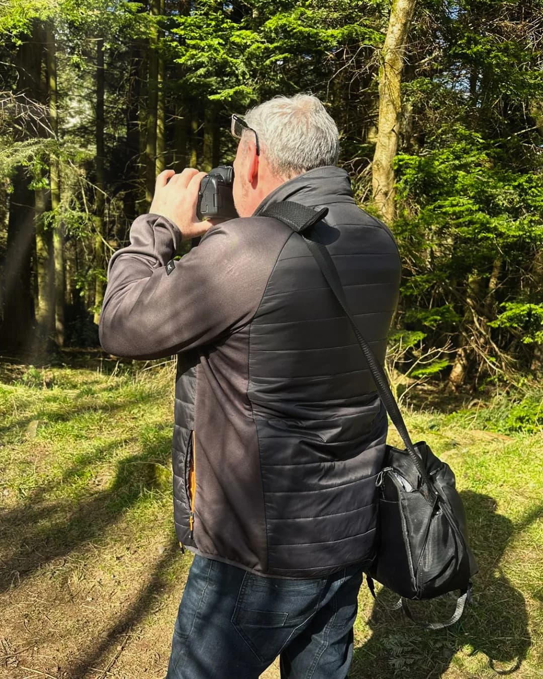 Photographer capturing content on location in woodland